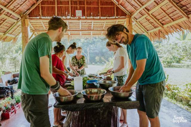 Travellers cooking together under the thatched roof at Rungfah Farm Stay in Khao Sok